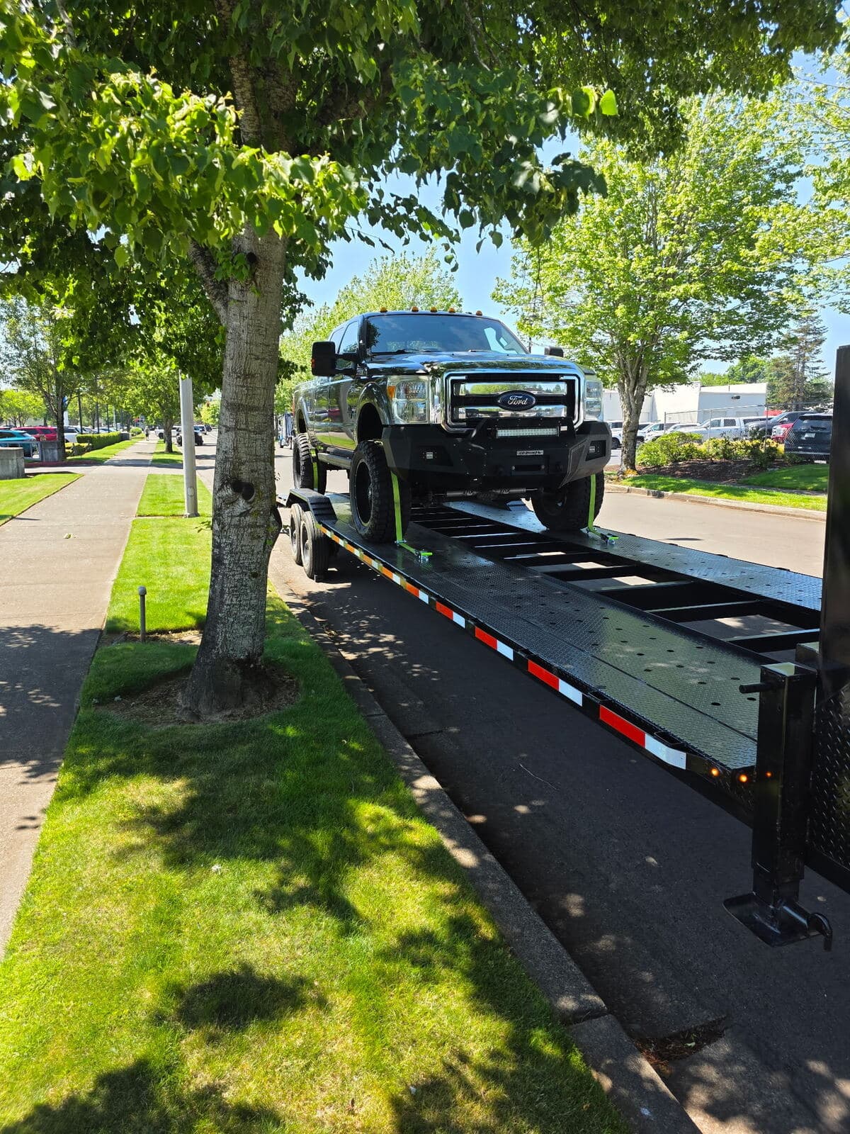 Lifted Ford Super Duty secured on Stellar Transport's two-vehicle trailer
